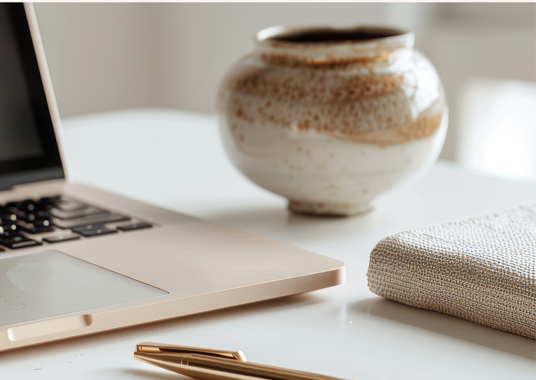laptop, pen and vase